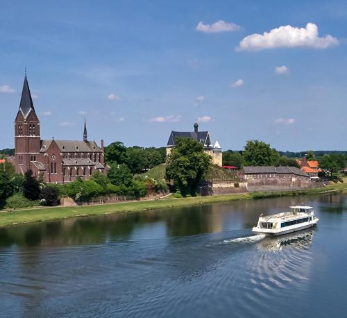 a boat traveling down a river in front of a castle at Klein Veers in Kessel