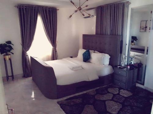 a bedroom with a large bed and a window at Gilpins Classic Penthouse in Lekki