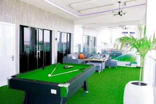a living room with a pool table on a green floor at Gilpins Classic Penthouse in Lekki