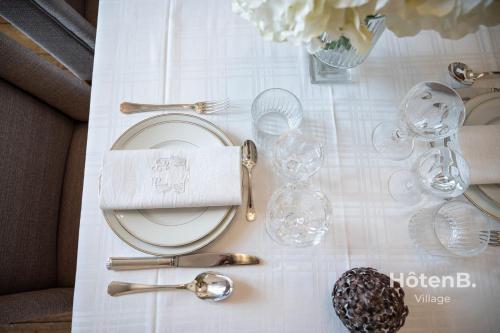une table avec un tissu de table blanc, des assiettes et des verres dans l'établissement 