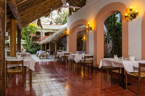 a dining room with tables and chairs in a restaurant at Villas Arqueologicas Chichen Itza in Chichén-Itzá