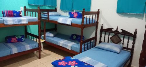 a room with three bunk beds with blue sheets at Pousada Ribeirinha in Aparecida
