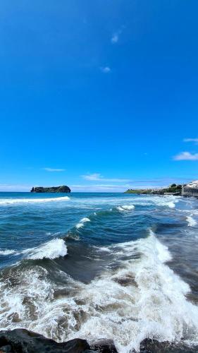 a view of the ocean with waves on the beach at Farol da Vila in Vila Franca do Campo
