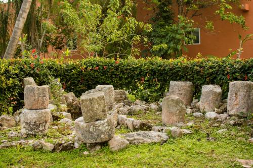 a group of stone monuments in a garden at Villas Arqueologicas Chichen Itza in Chichén-Itzá