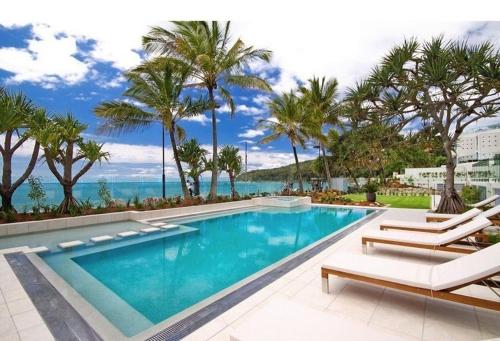 a swimming pool with a view of the ocean at Fairshore Apartment 28, Noosa Heads in Noosa Heads
