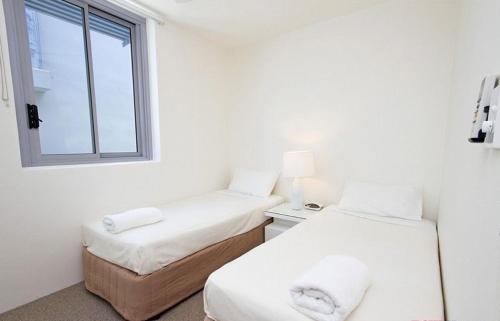 努沙岬的住宿－Fairshore Apartment 28, Noosa Heads，带窗户的客房内的两张床