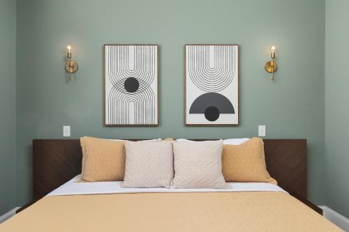 ナッシュビルにあるLuxury Design, Close to Broadway - 4 Beds, 2 Bedrmのベッドルーム1室(壁に2枚の写真が飾られたベッド1台付)