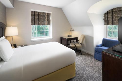 a bedroom with a bed and a desk and a chair at Andover Inn in Andover