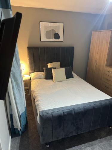 um quarto com uma cama grande e lençóis brancos em La mansion em Wednesbury