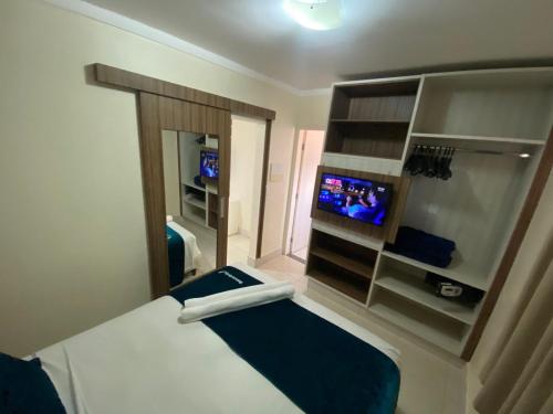 Habitación pequeña con cama y TV. en Lacqua diRoma Hotel com Parque Aquático 24 horas, en Caldas Novas