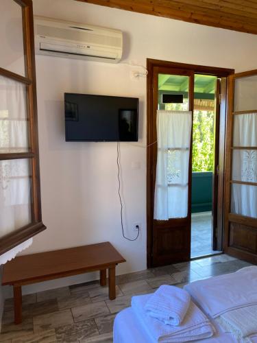 a bedroom with a tv on the wall and a bed at Pansion Vasso in Agios Nikitas