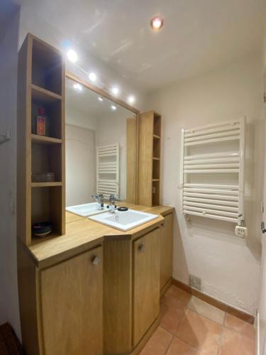 een badkamer met een wastafel en een spiegel bij La casa Bea in Cotignac