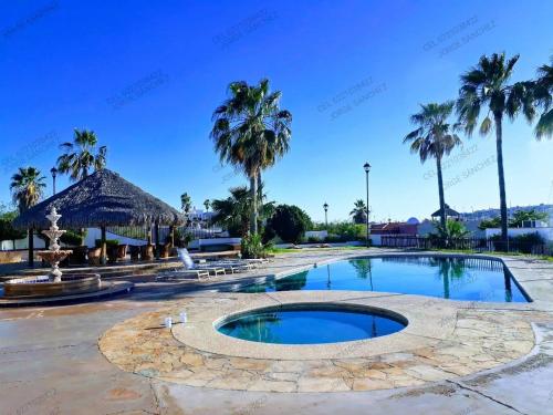 una piscina en un complejo con palmeras en Casa Villa Serena 8, en San Carlos
