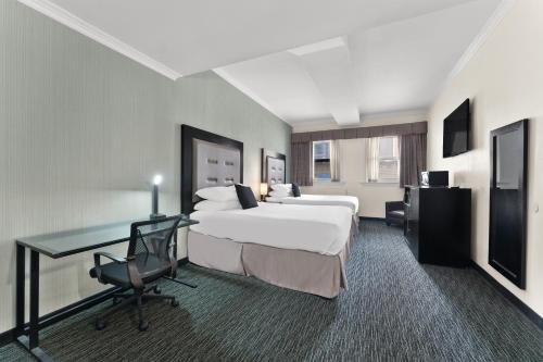 a hotel room with two beds and a desk at Quality Inn Center City Philadelphia in Philadelphia
