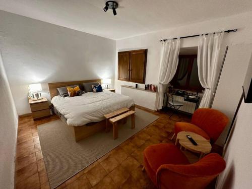 ein Schlafzimmer mit einem Bett und zwei Stühlen darin in der Unterkunft Lovely 2 Bedroom in San Gimignano Historic Center in San Gimignano