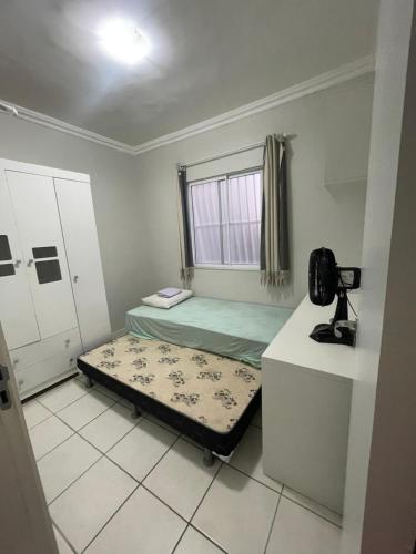 a small room with a bed and a window at Apartamento próximo ao aeroporto in Fortaleza