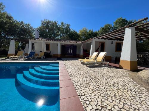 a villa with a swimming pool and a house at Quinta do Faisco in Évora