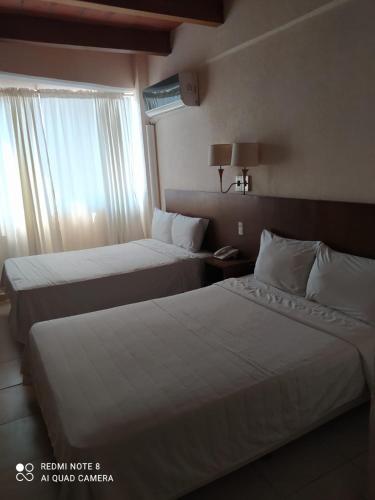 a hotel room with two beds and a window at Gran Santiago Plaza in Santiago Tuxtla
