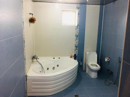 a bathroom with a white tub and a toilet at BakuHome in Baku