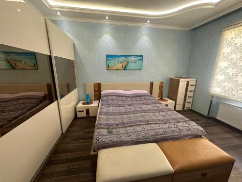 a small bedroom with a bed and two tables at BakuHome in Baku