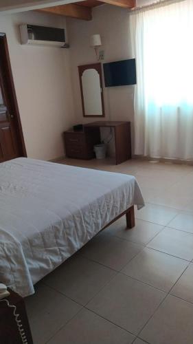 a bedroom with a bed and a mirror and a window at Gran Santiago Plaza in Santiago Tuxtla