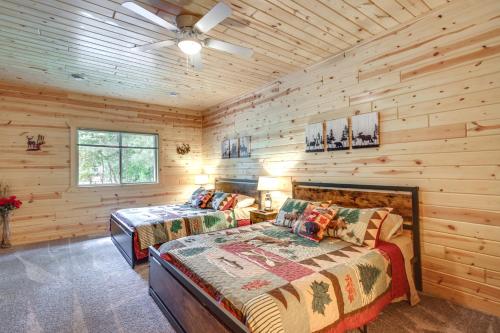 a bedroom with two beds in a log cabin at Pequot Lakes Vacation Rental with Patio and Fire Pit in Pequot Lakes