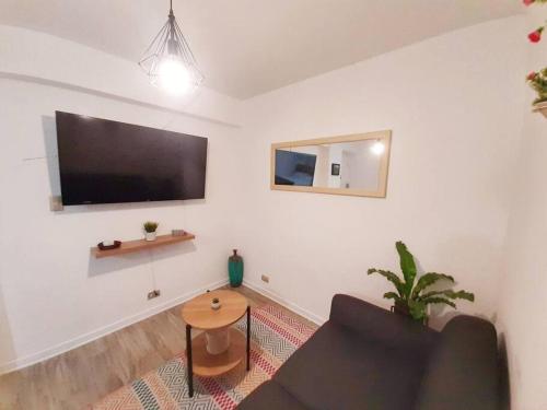 a living room with a couch and a flat screen tv at Miraflores Beautiful Studio! in Lima