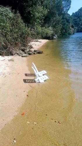 a plane laying on the sand on a beach at Quinta da Ribeirinha - Douro River in Paços de Gaiolo