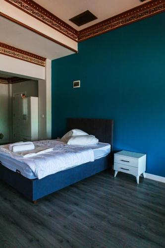 1 dormitorio con 1 cama grande y pared azul en YALI HOUSE en Estambul
