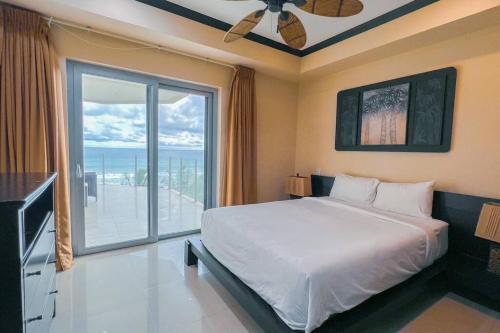 - une chambre avec un grand lit et une grande fenêtre dans l'établissement Luxury beach condo, stunning sunset & ocean view, à Jacó
