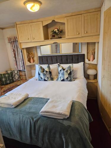 Portlaw的住宿－Mount bolton mobile home，一间卧室配有一张大床和毛巾