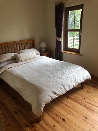 a bedroom with a large bed and a window at 2 Ballyloskey Road in Carndonagh
