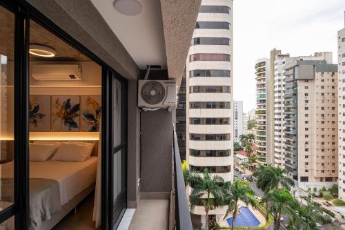 sypialnia z łóżkiem na balkonie z budynkiem w obiekcie Lindos apto com piscina no Setor Oeste IDV w mieście Goiânia