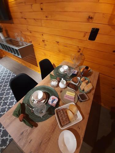 a wooden table with a plate of food on it at Pousada Recanto da Cascata - Cabana Platano in São Joaquim