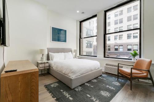 een slaapkamer met een bed, een bureau en een raam bij The Ledger Residences by Sosuite - Old City in Philadelphia