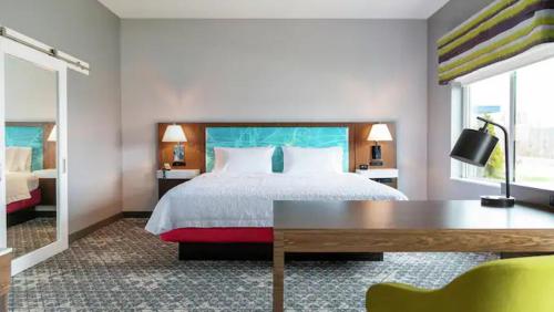 a hotel room with a bed and a desk in it at Hampton Inn & Suites Ruskin I-75, FL in Ruskin