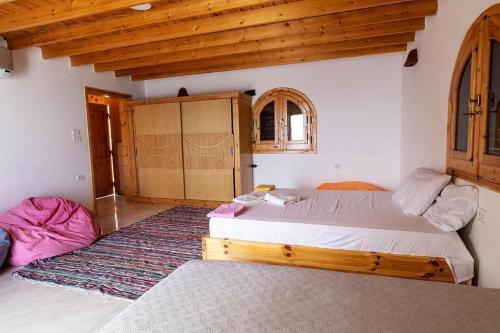 a bedroom with two beds in a room with wooden ceilings at Marine Garden Camp in Dahab