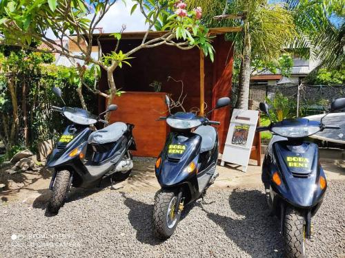 twee scooters geparkeerd voor een huis bij Bora Rent lodge in Bora Bora