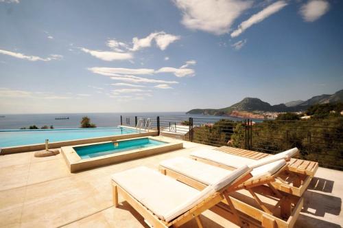a house with a swimming pool and a patio with chairs at Villa Redzic Residence in Brca