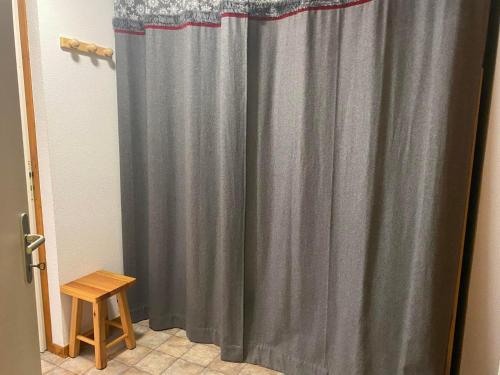 - un rideau de douche gris dans une salle de bains avec un tabouret dans l'établissement Appartement 2 pièces à Châtel - 4 pers, balcon exposé sud, proche télécabine et navettes gratuites - FR-1-198-253, à Châtel