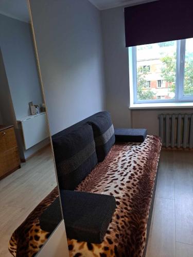 a living room with a couch in front of a window at Small studio beween the Old Town and the airport in Rīga