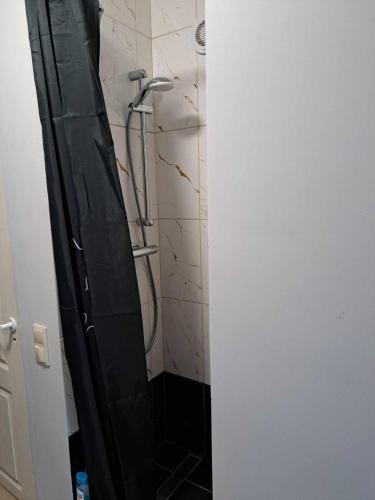 a bathroom with a shower with a black door at Small studio beween the Old Town and the airport in Rīga