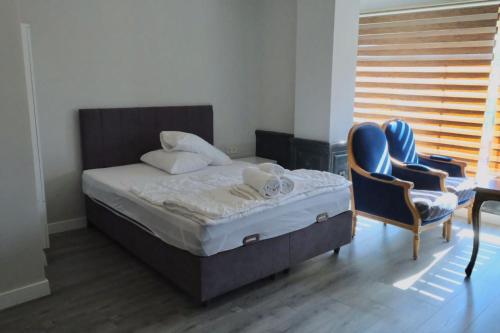 a bedroom with a bed and a blue chair at Yalı Houses in Istanbul
