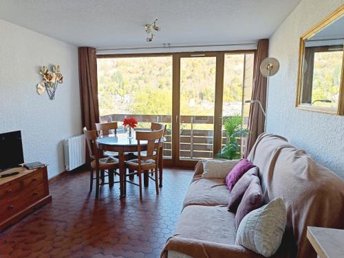 un salon avec un canapé et une table dans l'établissement Les Chardonnerets, à Le Mont-Dore