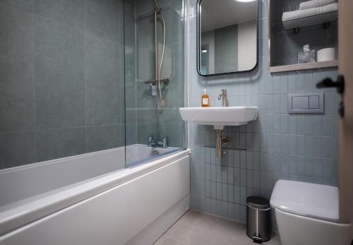 a bathroom with a sink and a tub and a toilet at Warwick Conferences - Scarman in Coventry