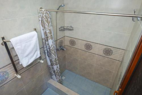 uma casa de banho com um chuveiro e uma toalha branca em Hotel Latif em Bukhara