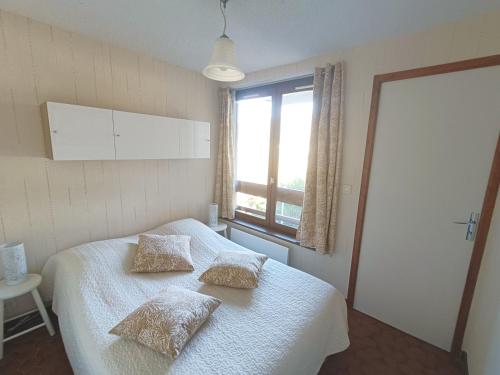 une chambre avec un lit avec deux oreillers dessus dans l'établissement Les Chardonnerets, à Le Mont-Dore