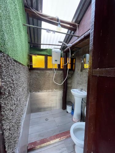 y baño con aseo y lavamanos. en Ecolodge las tunas en Cuzco