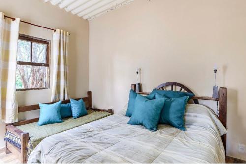 1 dormitorio con 1 cama grande con almohadas azules en Casa completa em Santana de Parnaíba en Santana de Parnaíba