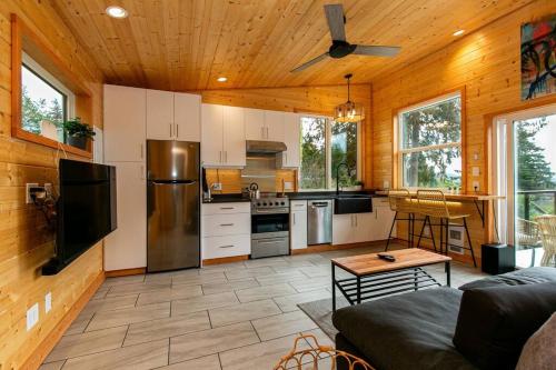 a large kitchen with a couch and a table at 1-bedroom knotty Pine cabin w sauna & jacuzzi in Sooke